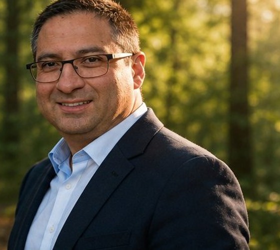 Jim, I Go Forward Coaching founder, standing outdoors in a sunlit forest